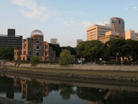 Figura 5 - L'Atomic Bomb Dome, unico edificio sopravvissuto al bombardamento atomico del 6 agosto 1945,  sullo sfondo di una città grande, moderna e vitale.