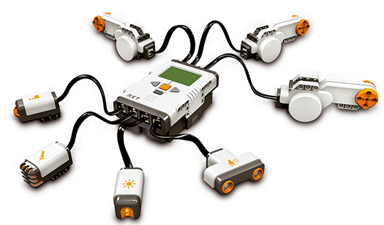 Figura 7 - Il kit Lego Mindstorm. L'unità di controllo programmabile è visibile al centro. In alto sono visibili i tre attuatori, mentre in basso, da sinistra a destra, sono visibili un sensore di contatto, un sensore di suono, un rivelatore di luminosità e un sonar.